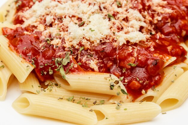 Fechar na refeição penne com molho vermelho e queijo ralado, fundo preto