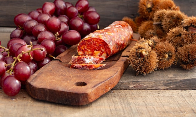 Fechar o chouriço de castanhas e uvas na mesa de madeira rústica