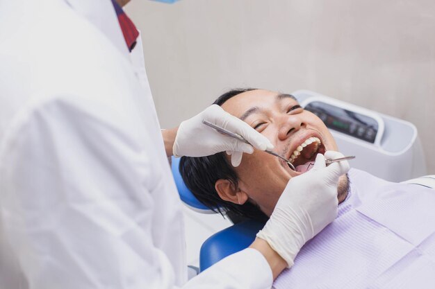 Fechar o dentista examinando os dentes dos pacientes