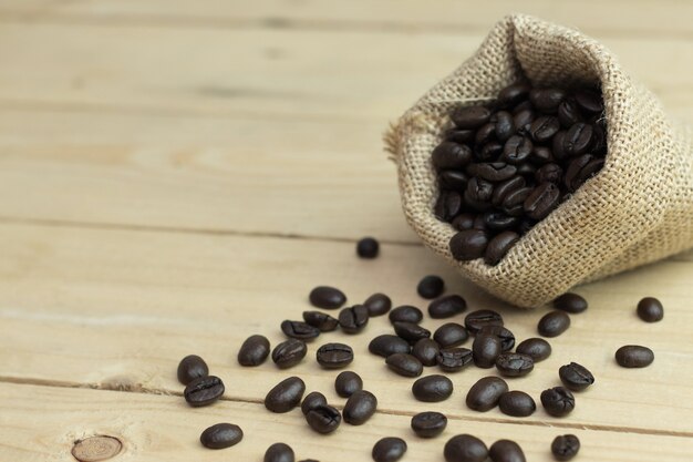 Fechar o grão de café torrado na mesa de madeira velha