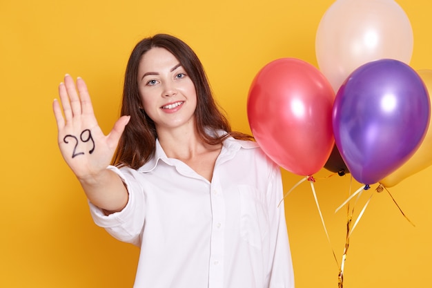 Fechar o retrato de mulher jovem alegre com balões de festa na mão