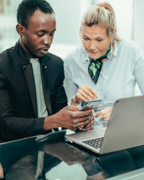 Fechar-se. colegas de trabalho discutindo notícias online no local de trabalho.