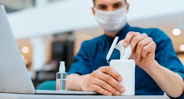 Foto fechar-se. funcionário usando lenços anti-sépticos no local de trabalho