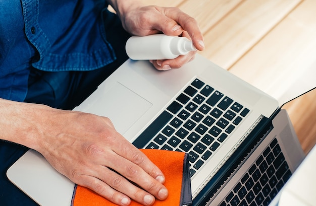 Fechar-se. jovem descontaminando seu laptop. conceito de proteção à saúde