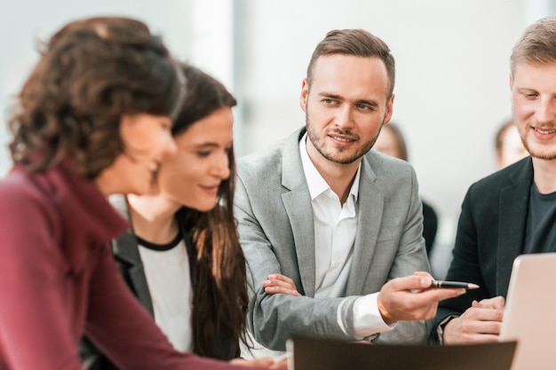 Fechar-se. jovens funcionários discutindo problemas em uma reunião de grupo.