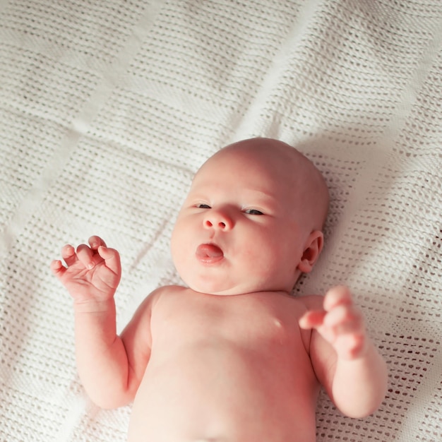 Fechar-se. um lindo bebê recém-nascido deitado sobre uma toalha.