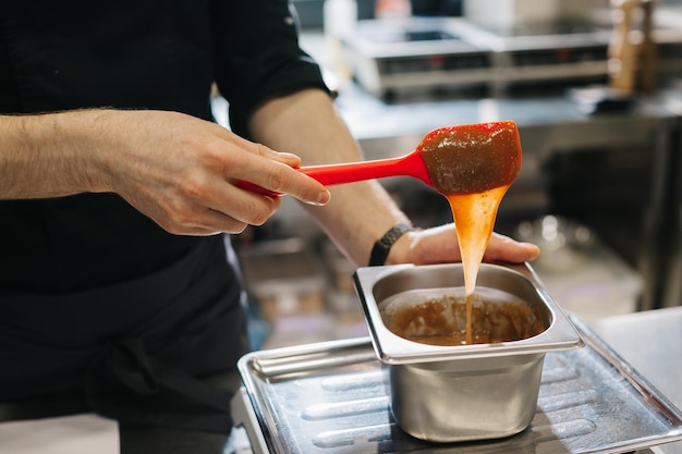 Fechar Um chef faz ganache para decorar sobremesas