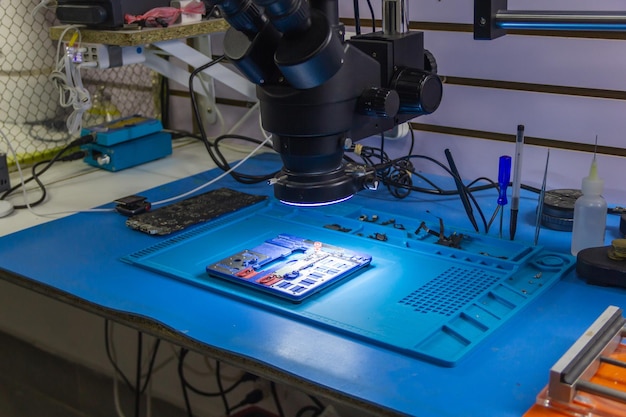 Fechar um microscópio para técnicos que trabalham no reparo de telefones celulares