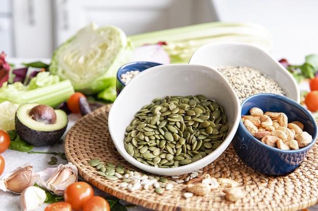 Fechar uma tigela de sementes de abóbora e outros alimentos saudáveis na mesa da cozinha