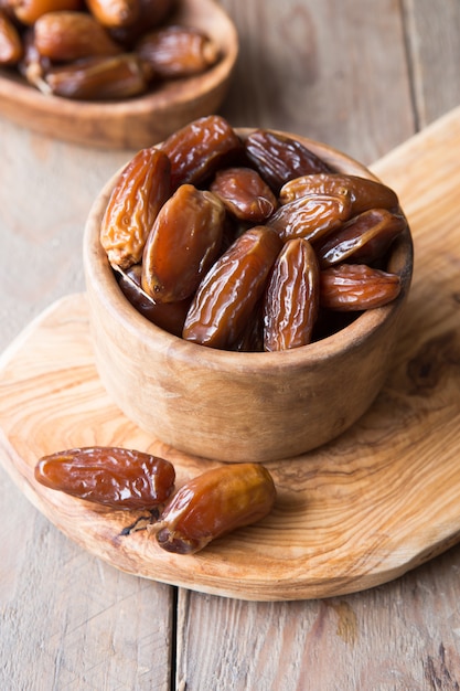 Fechas de fruta de palma en tazón de madera es merienda saludable.