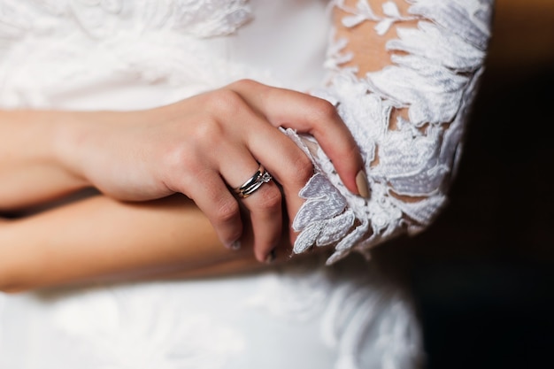 Feche a aliança de metal precioso no dedo da noiva.