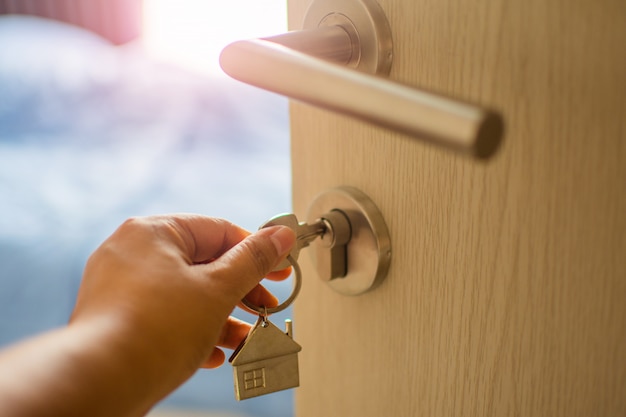 Feche a chave de toque de mão humana na porta com luz da manhã, empréstimo pessoal. o assunto está embaçado.