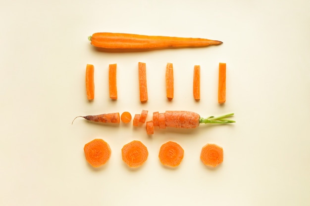 Feche a composição com cenouras frescas maduras e fatias