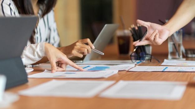 feche a consultoria da equipe de negócios na sala de reuniões com relatório financeiro e suprimentos para laptop