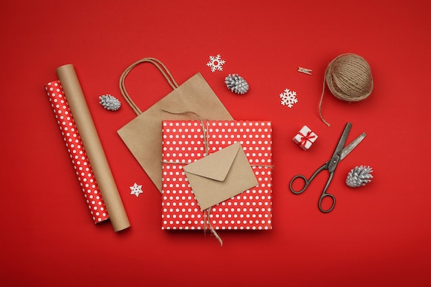 Feche a embalagem e embrulhe os presentes de Natal com papel vermelho e marrom, vista de cima da mesa, lay-out