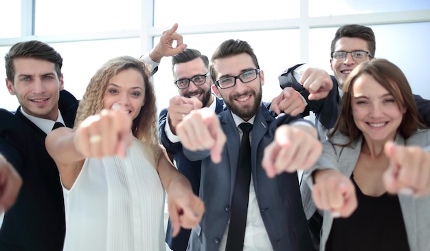 Feche a equipe de negócios sorridente apontando para você o conceito de escolha