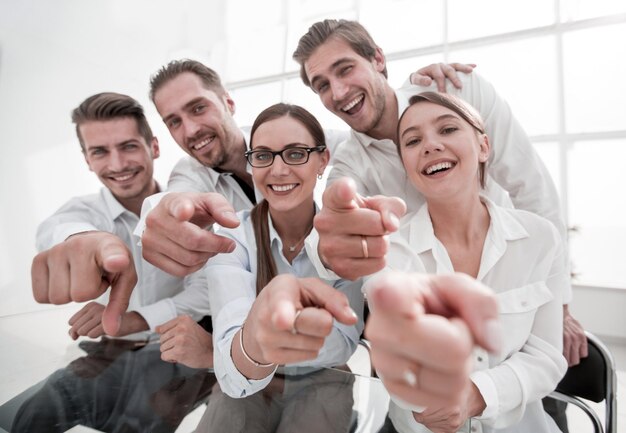 Feche a equipe de negócios sorridente apontando para você