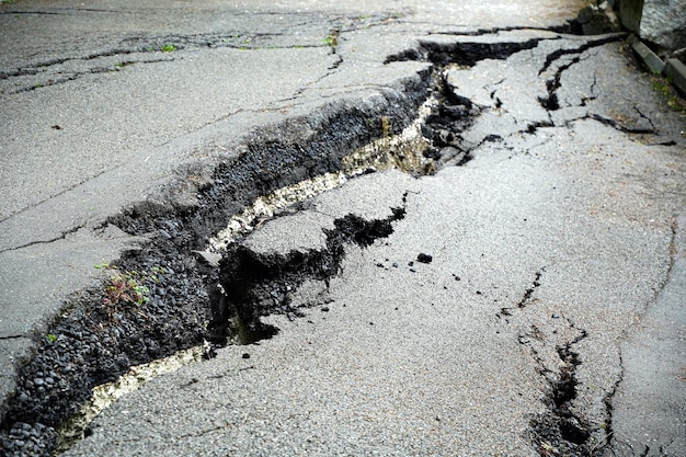 Feche a estrada de asfalto rachada e quebrada pelo terremoto