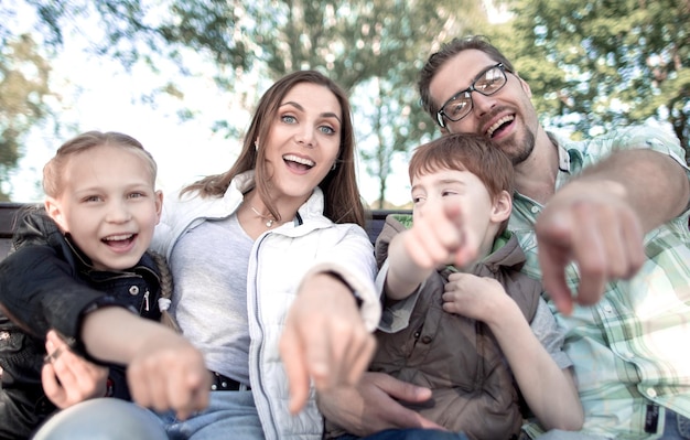 Feche a família sorridente apontando para você o conceito de lazer familiar