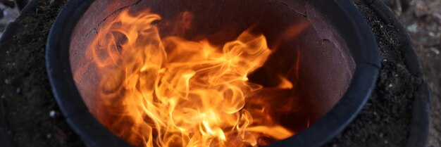 Feche a fogueira em uma panela de cerâmica rachada, acampe ao ar livre, viaje e cozinhe em fogo aberto