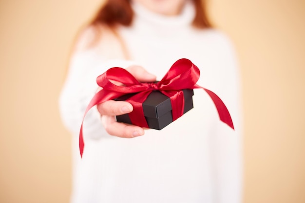 Feche a foto da caixa de presente nas mãos femininas Mulher segurando a caixa de presente Dia dos namorados Conceito de aniversário ou feriados Copiar espaço