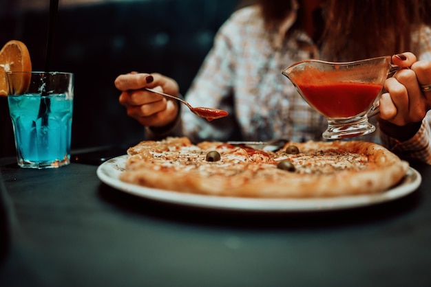 Feche a foto de uma mulher de negócios comendo pizza na hora do almoço foco seletivo