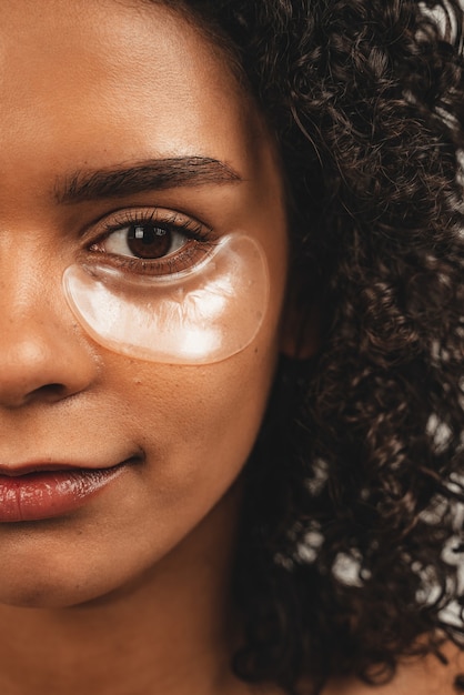 Feche a foto de uma mulher negra atraente de rosto com manchas sob os olhos. Isolado sobre fundo branco.