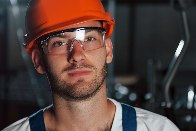 Feche a foto. retrato do engenheiro em uma fábrica metalúrgica em capacete protetor e óculos.
