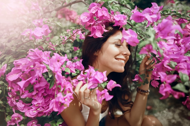 Foto feche a garota do retrato no parque em um fundo de flores cor de rosa