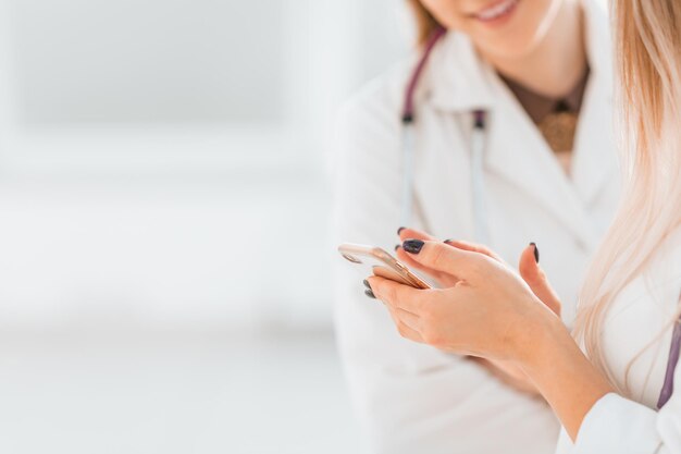 Feche a imagem de fundo de colegas médicos lendo uma mensagem em um smartphone