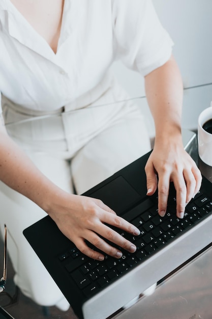 Feche a imagem de uma mulher trabalhando em home office trabalhando remotamente e digitando no teclado mãos close-up mulher freelancer conversando pela internet em redes sociais