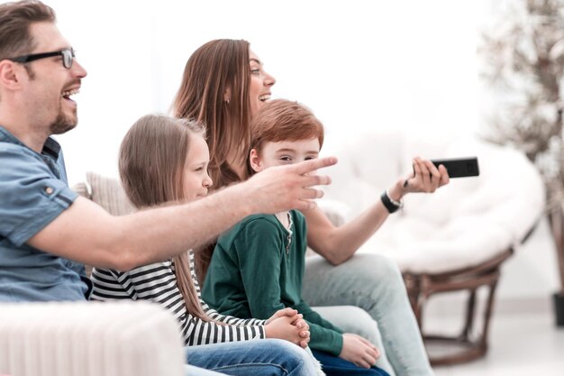 Foto feche a jovem família descansando na sala de estar à noite