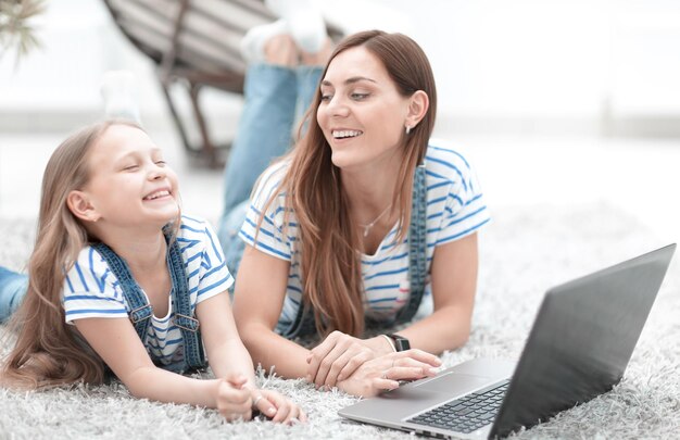 Feche a mãe e sua filha brincando no laptop