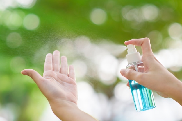 Feche a mão com spray desinfetante de álcool ao ar livre