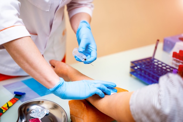 Feche a mão da enfermeira executando análise de amostra de sangue para diagnóstico e tratamento de um paciente. diagnóstico de química do sangue por máquina automática. fechar-se.