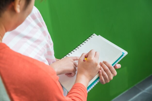 Feche a mão de estudantes adolescentes estudando juntos