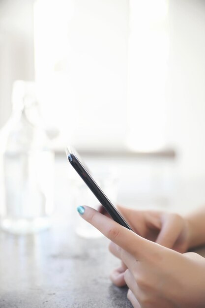 Feche a mão de uma mulher segurando estoque de negociação de smartphones e dados no conceito de negócios de fundo de cafeteria