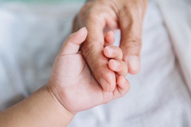 Feche a mão do bebê nas mãos da mãexA