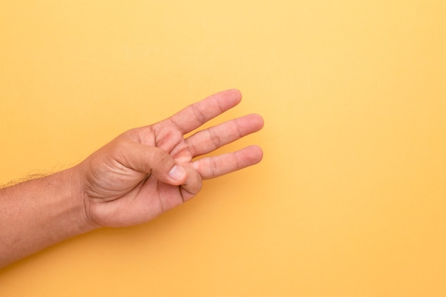 Feche a mão mostrando um gesto de três dedos