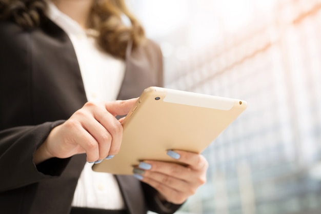 Feche a mão Mulher de negócios trabalhando usando um tablet digital