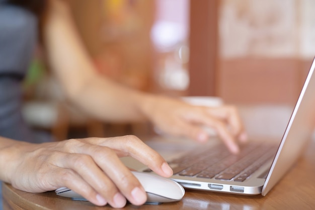 Feche a mão pessoas pessoa mulher no computador laptop usando telefone celular sente-se no chão de madeira.