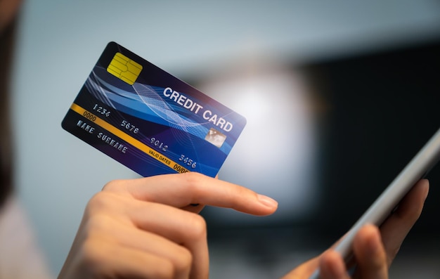 Foto feche a mão segurando o cartão de crédito com pagamento on-line no smartphone na loja da internet.