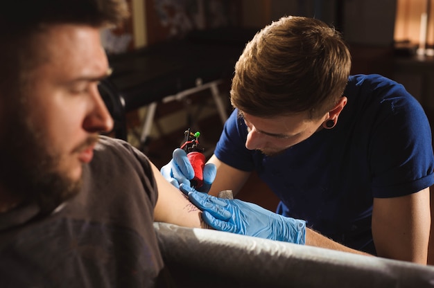 Feche a máquina de tatuagem. homem, criando, quadro, mão, aquilo, salão