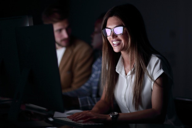 Feche a mulher de negócios sorridente trabalhando no computadorfoto em fundo preto