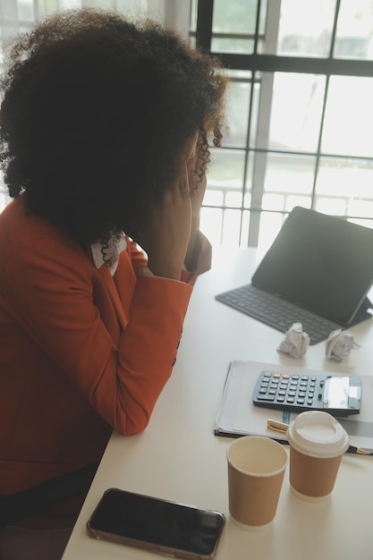 Feche a mulher de negócios usando calculadora e laptop para fazer finanças matemáticas em estatísticas de contabilidade fiscal de mesa de madeira e conceito de pesquisa analítica