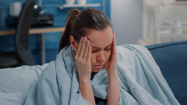 Feche a mulher doente com enxaqueca esfregando os templos para curar a doença do vírus. pessoa com dor de cabeça com sintomas de gripe sazonal, tentando curar a dor e a doença. adulto com coronavírus