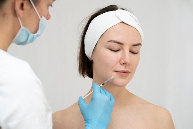 Foto feche a mulher durante o procedimento de preenchimento labial