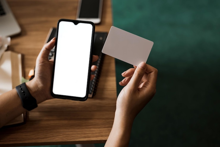 Foto feche a mulher segurando o celular com uma tela branca e cartão de crédito conceito de compras on-line