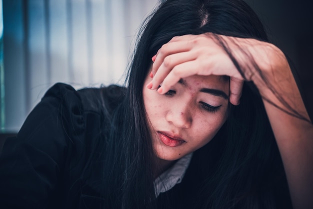 Feche a mulher triste na estressada do escritório do trabalho duroDesgosto do namoradoTailândia