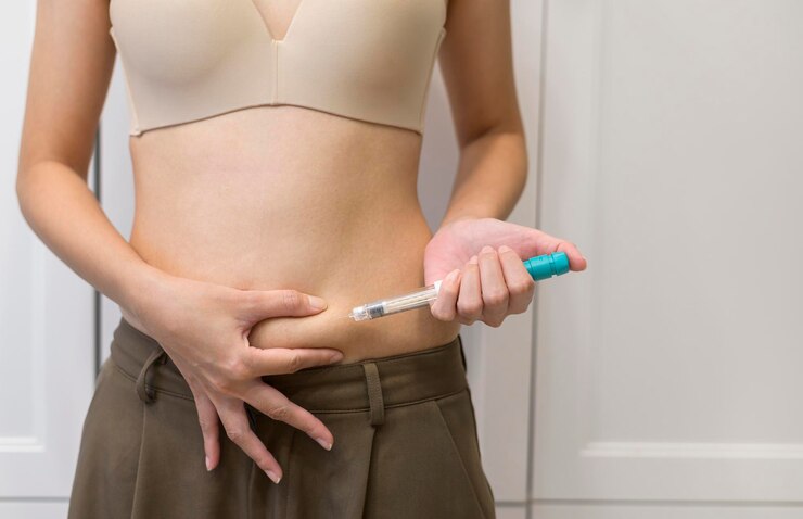 Feche a mulher usando injeção de tratamento de fertilização in vitro na barriga para preparar a reprodução